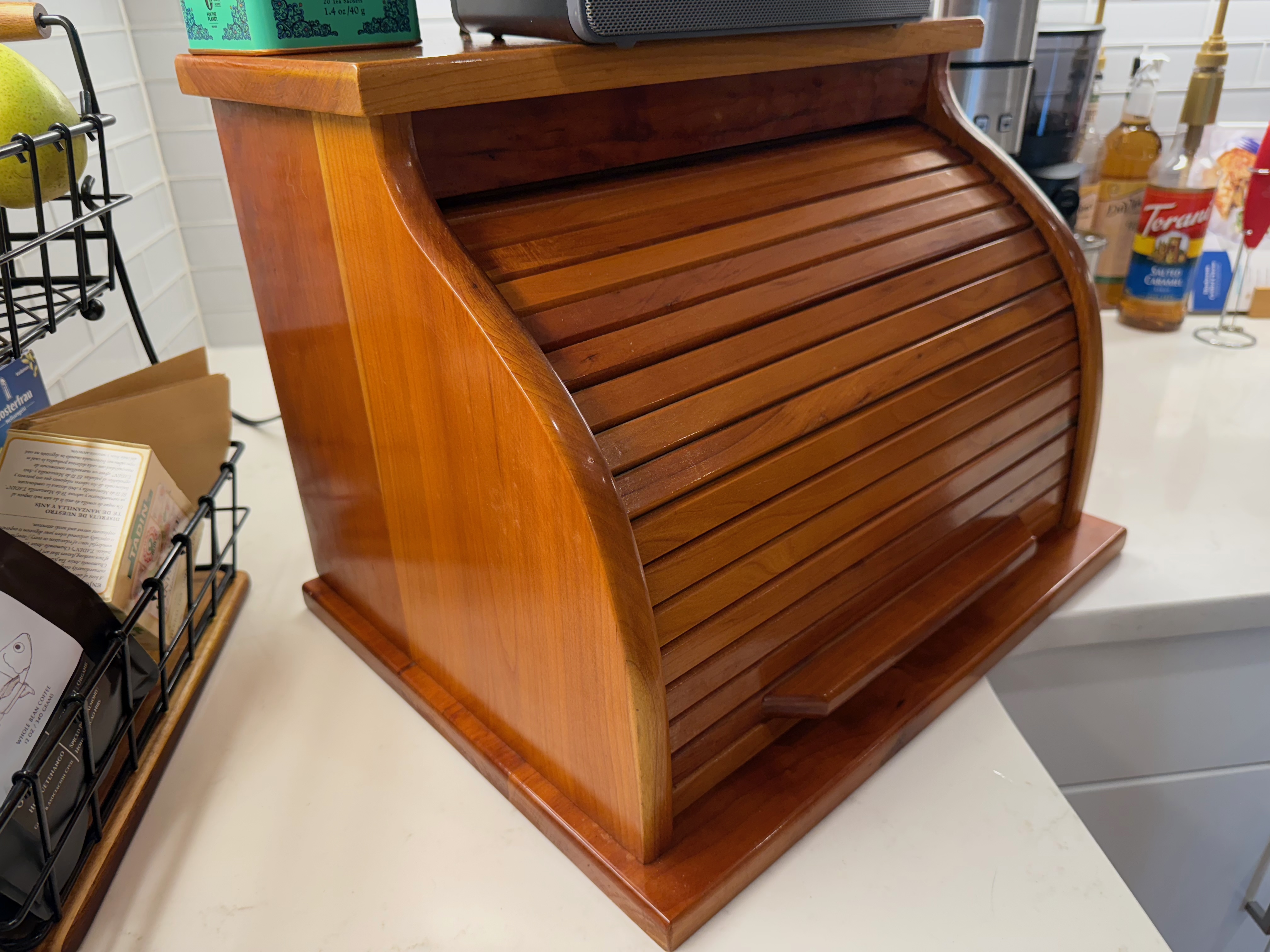 Two joined boards making up the side of the bread box.