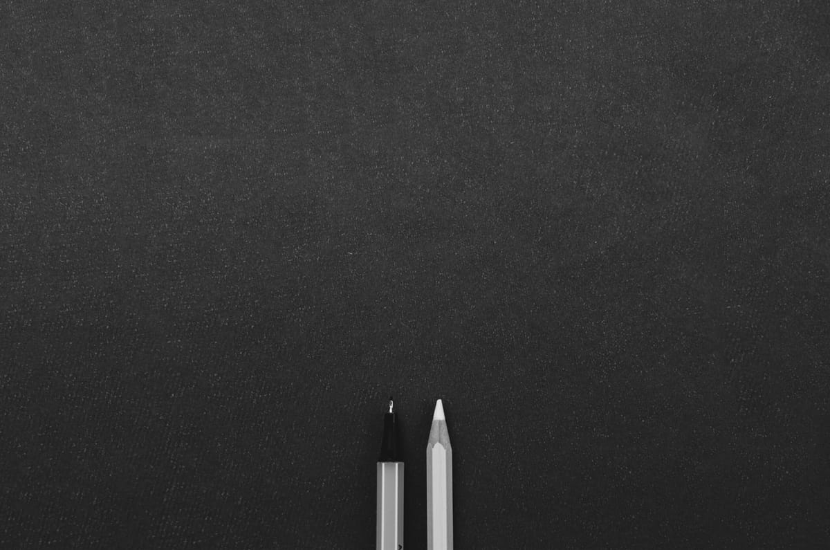 Writing tools on a blank black background.